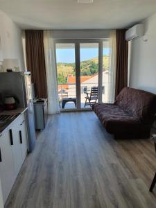 ein Wohnzimmer mit einem Sofa und eine Küche mit einem Balkon in der Unterkunft Vesna Lake Apartments in Veles