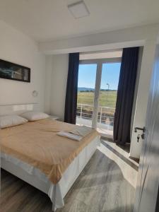 a bedroom with a bed and a large window at Vesna Lake Apartments in Veles