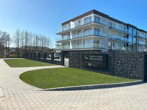 a building with a sign in front of it at Sea & Home in Gąski