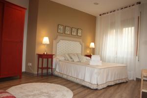 1 dormitorio con 1 cama blanca grande y ventana en Apartamento Turístico Cigüeña de Alfaro, en Alfaro