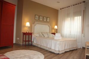 a bedroom with a large white bed with a window at Apartamento Turístico Cigüeña de Alfaro in Alfaro