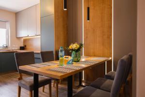 a dining room table with a vase of flowers on it at Charming Family Haven in Oradea