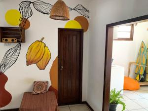 una habitación con una puerta y una pared con flores en Rudá Hostel, en Itacaré