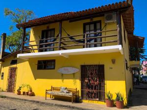 un edificio amarillo con un banco delante de él en Rudá Hostel, en Itacaré