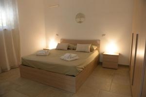 a bedroom with a bed with two towels on it at Il Giardino dei Ricordi in Alberobello