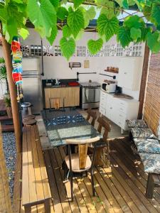 uma cozinha com uma mesa e algumas cadeiras em Suítes Cabanas Coral em Serra