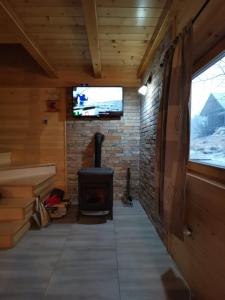 a room with a fireplace and a tv on a wall at Brvnare Libero TARA in Sekulić  +17 photos
