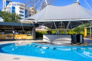 uma grande piscina com um grande guarda-chuva sobre ela em Effect Grand Victoria Hotel - Ultra All Inclusive em Sunny Beach