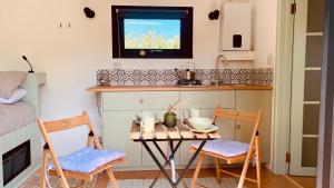 a small kitchen with a table and two chairs at Apple Orchard Shepherd Huts in Staple Cross
