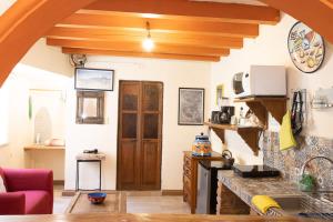 a kitchen with wooden ceilings and a living room at Lofts Las Cuatro Puertas in Guanajuato