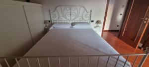 a large bed in a bedroom with a metal headboard at LA MAISON ROSE in Leggiuno