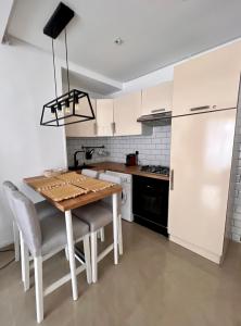 een keuken met een houten tafel en stoelen en een koelkast bij Smart Holiday Cabo Negro in Cabo Negro