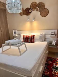 a bedroom with a large white bed with a table at Smart Holiday Cabo Negro in Cabo Negro
