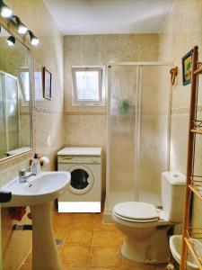 y baño con lavabo, aseo y lavadora. en El Capricho, en Benalup-Casas Viejas