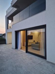 une grande fenêtre en verre d'une maison avec un canapé dans l'établissement MA Apartments, à Senj