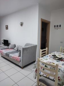 ein Wohnzimmer mit einem Sofa und einem Bett in der Unterkunft SummerhouseVelipoje-Te Kompleksi Fishta-Q1,36 in Velipojë