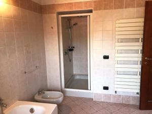 a bathroom with a shower and a toilet and a sink at LA MAISON ROSE in Leggiuno