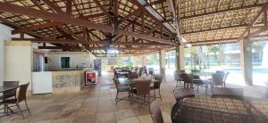a dining room with tables and chairs in a building at Apto Vista Mar alto padrão Paraíso das Dunas in Aquiraz