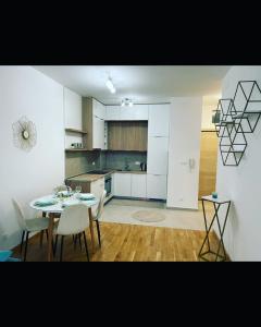 a kitchen with a table and chairs in a room at Apartman Iva in Tivat