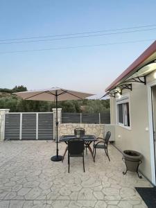 eine Terrasse mit einem Tisch, Stühlen und einem Sonnenschirm in der Unterkunft Elia House in Chania