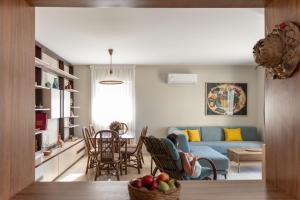 uma sala de estar e cozinha com um sofá azul em Aelia seafront house em Kokkíni Khánion