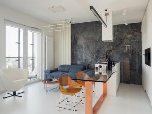 een woonkamer met een blauwe bank en een tafel bij Apartament 18 piętro UNIQUE APARTMENTS 4 YOU in Warschau