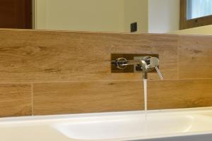 a bathroom sink with a faucet with water coming out at Chalet Pineta relax location in Canazei