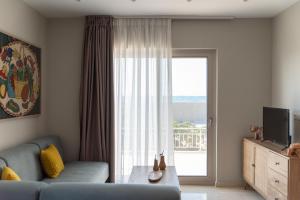 庫基尼坎尼奧的住宿－Aelia seafront house，客厅设有蓝色的沙发和大窗户