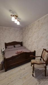 a bedroom with a wooden bed and a chair at Ambasador in Sibiu