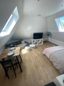 1 dormitorio con cama, mesa y sofá en Appartement entre terre et mer à proximité de Honfleur, en Équemauville