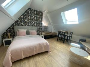 1 dormitorio con 1 cama grande con almohadas rosas en Appartement entre terre et mer à proximité de Honfleur, en Équemauville