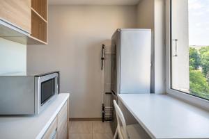 a kitchen with a refrigerator and a window at Apartament Sweet in Gdynia