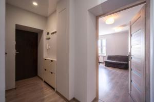 un couloir d'appartement avec une porte et un canapé dans l'établissement Apartament Sweet, à Gdynia