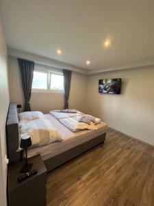 um quarto com uma cama e uma televisão na parede em FRESH Apartments em Ossiach