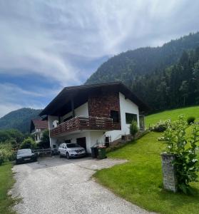 uma casa com um carro estacionado em frente em FRESH Apartments em Ossiach