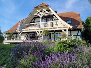 uma casa com flores roxas em frente em Romantik-Home Nordelsass - Ferienwohnung für Selbstversorger em Oberhoffen-lès-Wissembourg