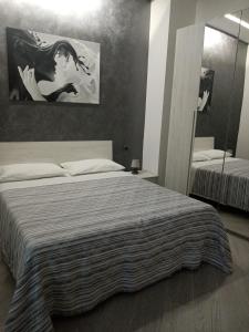 una camera da letto con un letto grande e uno specchio di Sa Benedica - Luxury House a Calatabiano