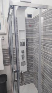 La salle de bains est pourvue d'une douche avec une porte en verre. dans l'établissement Sa Benedica - Luxury House, à Calatabiano