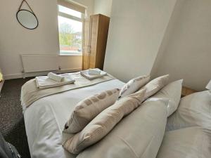 - une chambre avec un grand lit blanc et des oreillers dans l'établissement Entire house, Waterloo, free street parking, à Waterloo