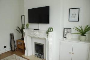a living room with a fireplace with a flat screen tv above it at Entire house, Waterloo, free street parking in Waterloo