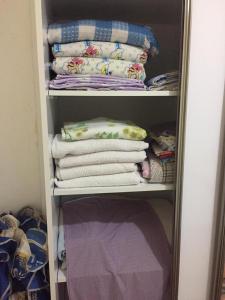 a closet filled with folded towels and pillows at SARIMSAKLI MEYDANINDA DENİZE 0 1+1 EŞYALI DAİRE in Ayvalık