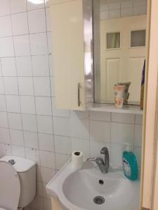 a bathroom with a sink and a toilet and a mirror at SARIMSAKLI MEYDANINDA DENİZE 0 1+1 EŞYALI DAİRE in Ayvalık