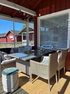 a screened in porch with a glass table and chairs at Hailuoto Marjaniemi - Rantasumppu Cottage 2 - With Sauna - Close to the beach in Hailuoto