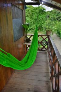 a hammock hanging from the side of a porch at Posada Nativa El Esfuerzo 2 in Nuquí