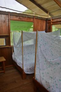 a bed in a room with a window at Posada Nativa El Esfuerzo 2 in Nuquí