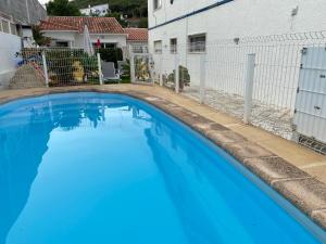 ein großer blauer Pool neben einem weißen Gebäude in der Unterkunft Casa Godinho in São Martinho do Porto