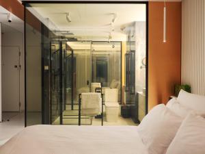 een slaapkamer met een wit bed en een badkamer bij Apartament 18 piętro UNIQUE APARTMENTS 4 YOU in Warschau