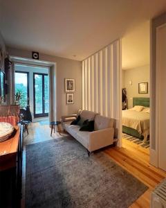 un soggiorno con divano e letto di Boavista Charming Apartment with Garden by Great&Cosy a Porto