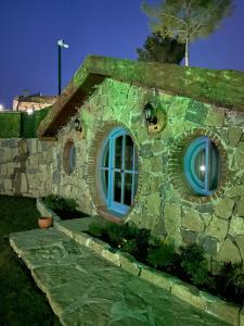 a house made out of a stone building with blue windows at Maison Green Hill in Antalya