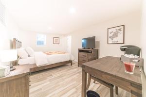 1 dormitorio con 1 cama y escritorio con TV en The Boston Rental - Multiple Floorplans en Boston